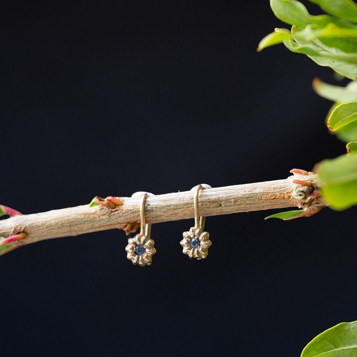 Orecchini a amo MandalaT Phytolacca in oro con pietra preziosa blu incastonata, design ispirato alla natura.